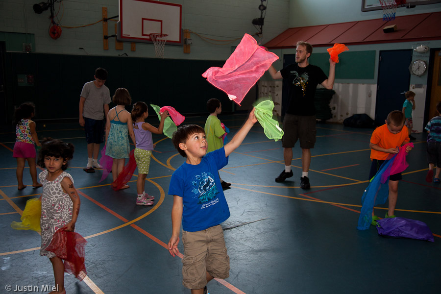 Kids learning scarf juggling in a school gym